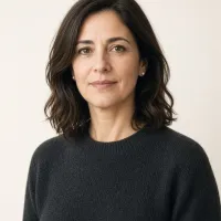 Elena Moretti in a charcoal sweater against a cream backdrop