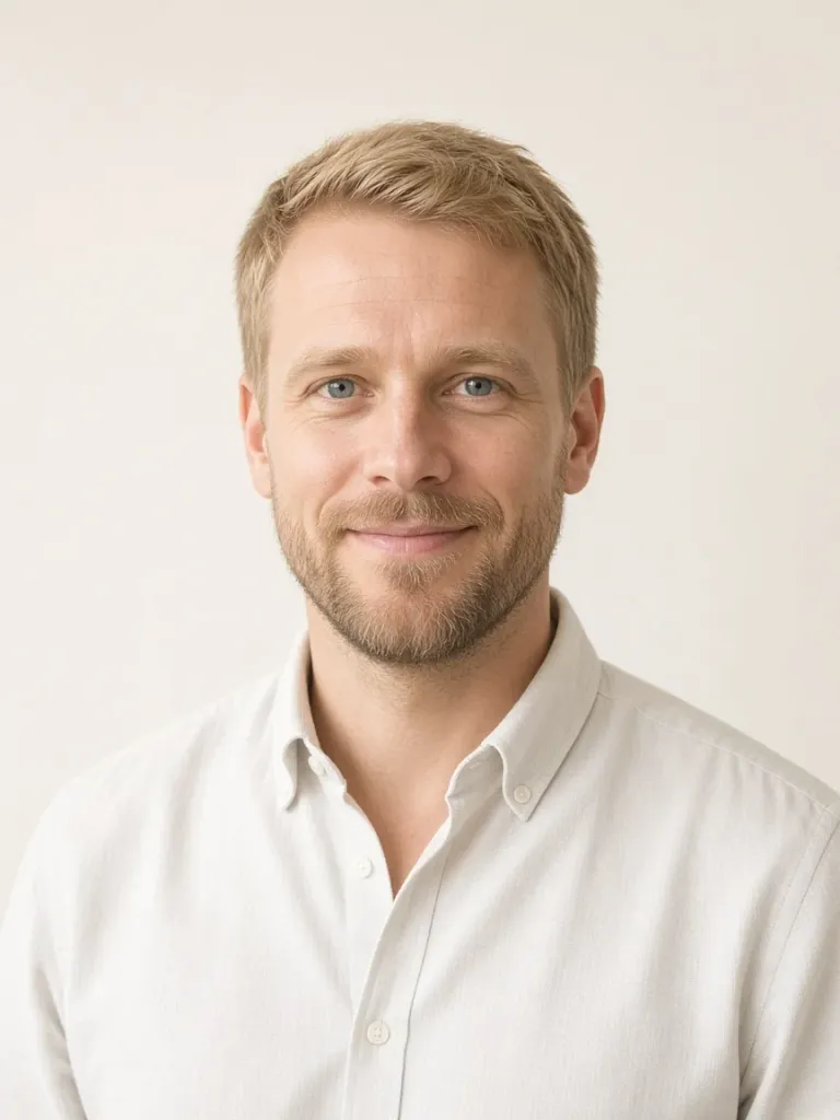Nils Halvorsen in a white oxford shirt against a cream backdrop